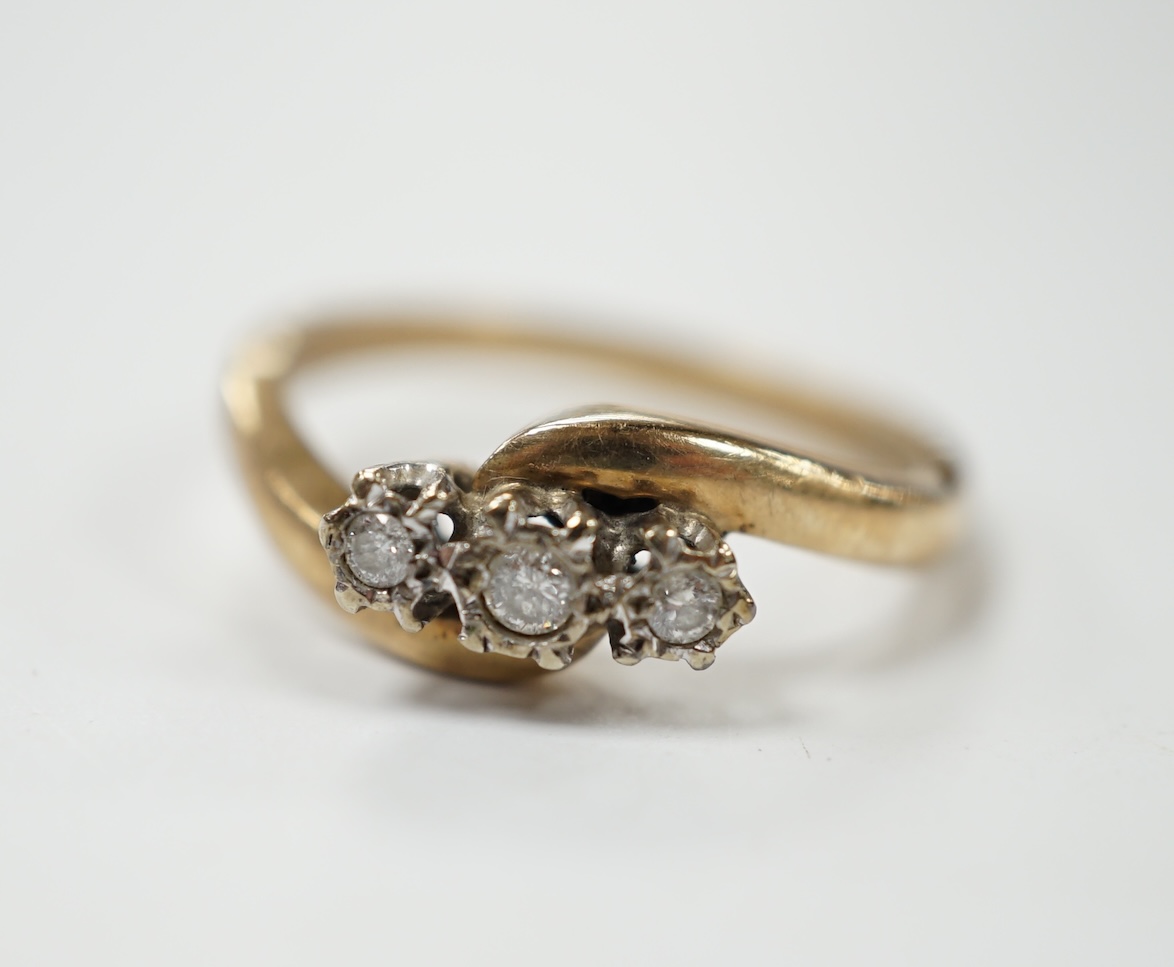 A modern 9ct gold and three stone diamond set cross-over ring, size P/Q, gross weight 3.4 grams. Condition - fair